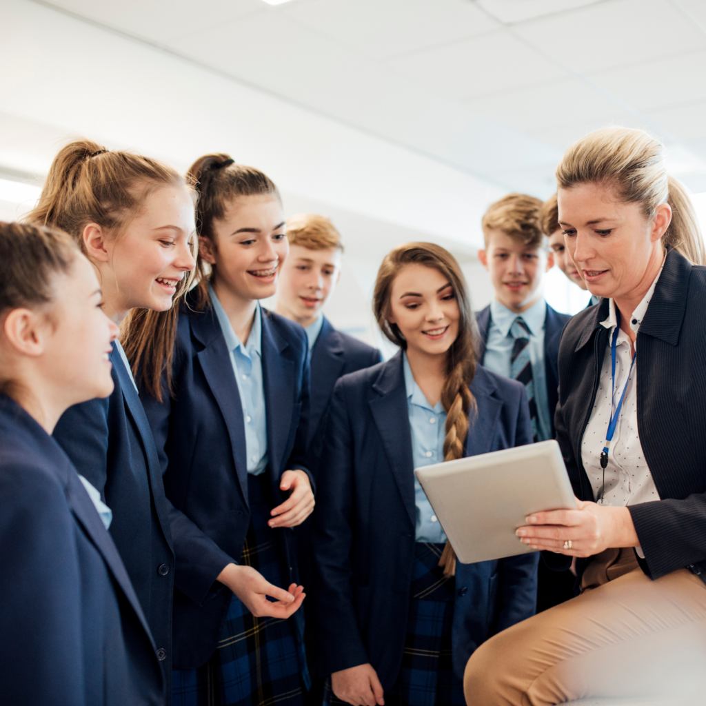 Nauczycielka pokazuje coś grupie uczniów