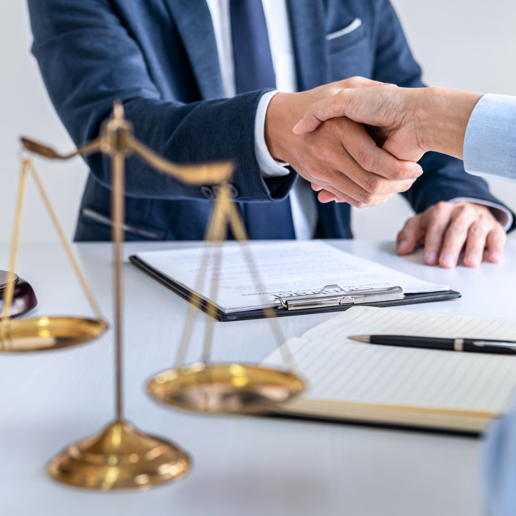 Waga oraz dwie osoby podające sobie dłonie